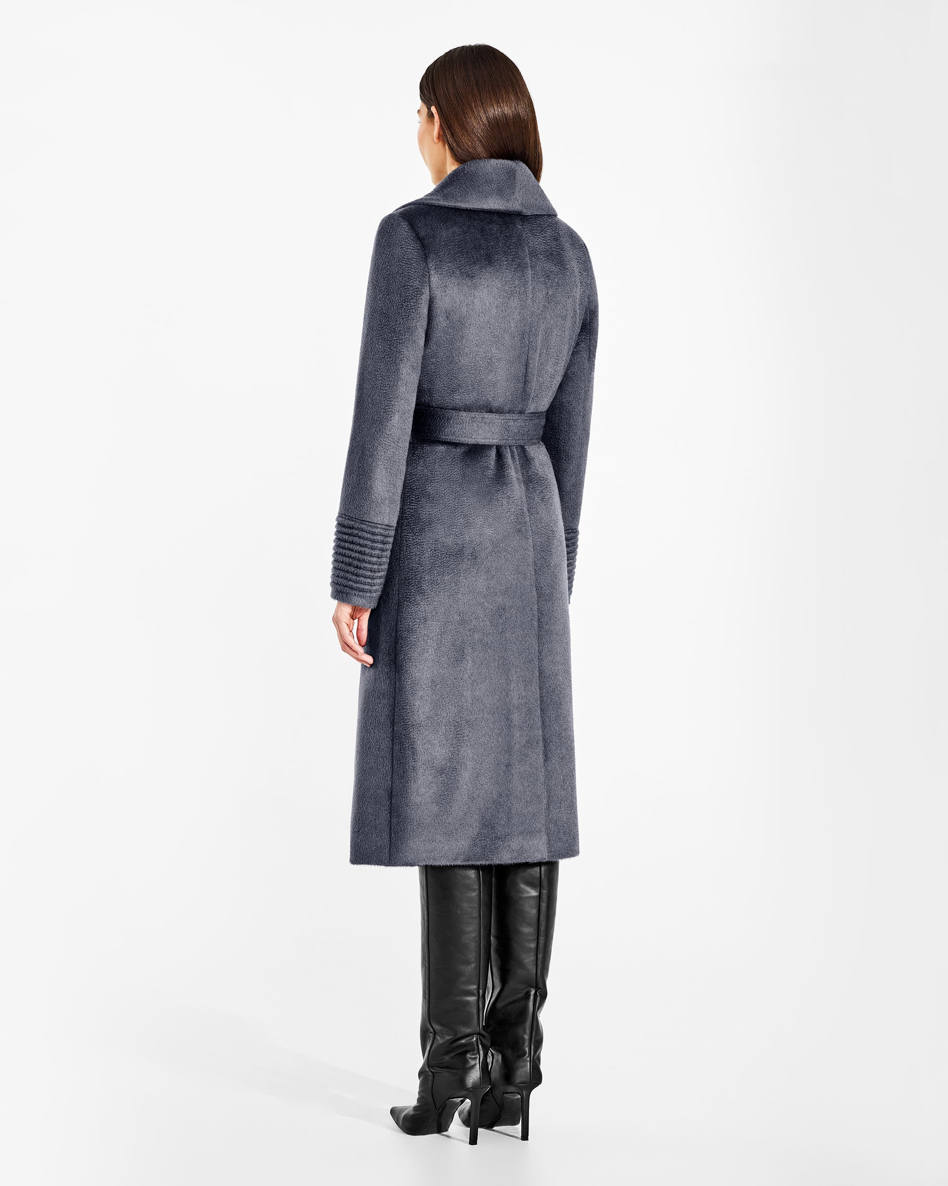 Back view of model wearing a Sentaler long graphite grey wrap coat made of suri alpaca wool, with a shawl collar, worn belted.