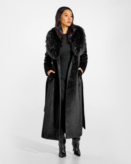 Front view of model wearing a Sentaler black maxi coat made of suri alpaca wool, with an alpaca shearling collar, seen open.