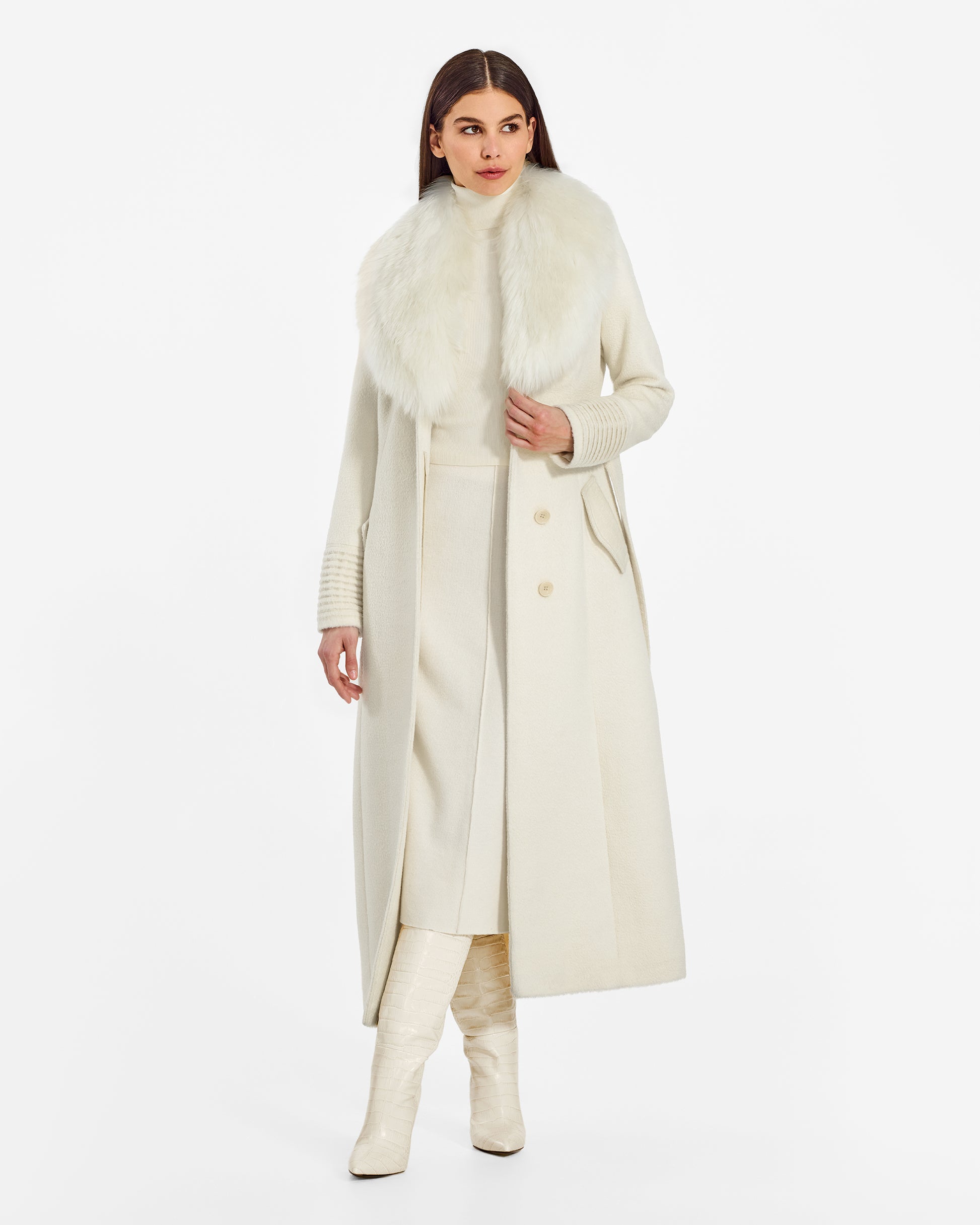 Front view of model wearing a Sentaler ivory maxi coat made of suri alpaca wool, with an alpaca shearling collar, seen open.