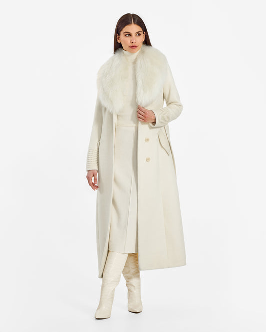 Front view of model wearing a Sentaler ivory maxi coat made of suri alpaca wool, with an alpaca shearling collar, seen open.