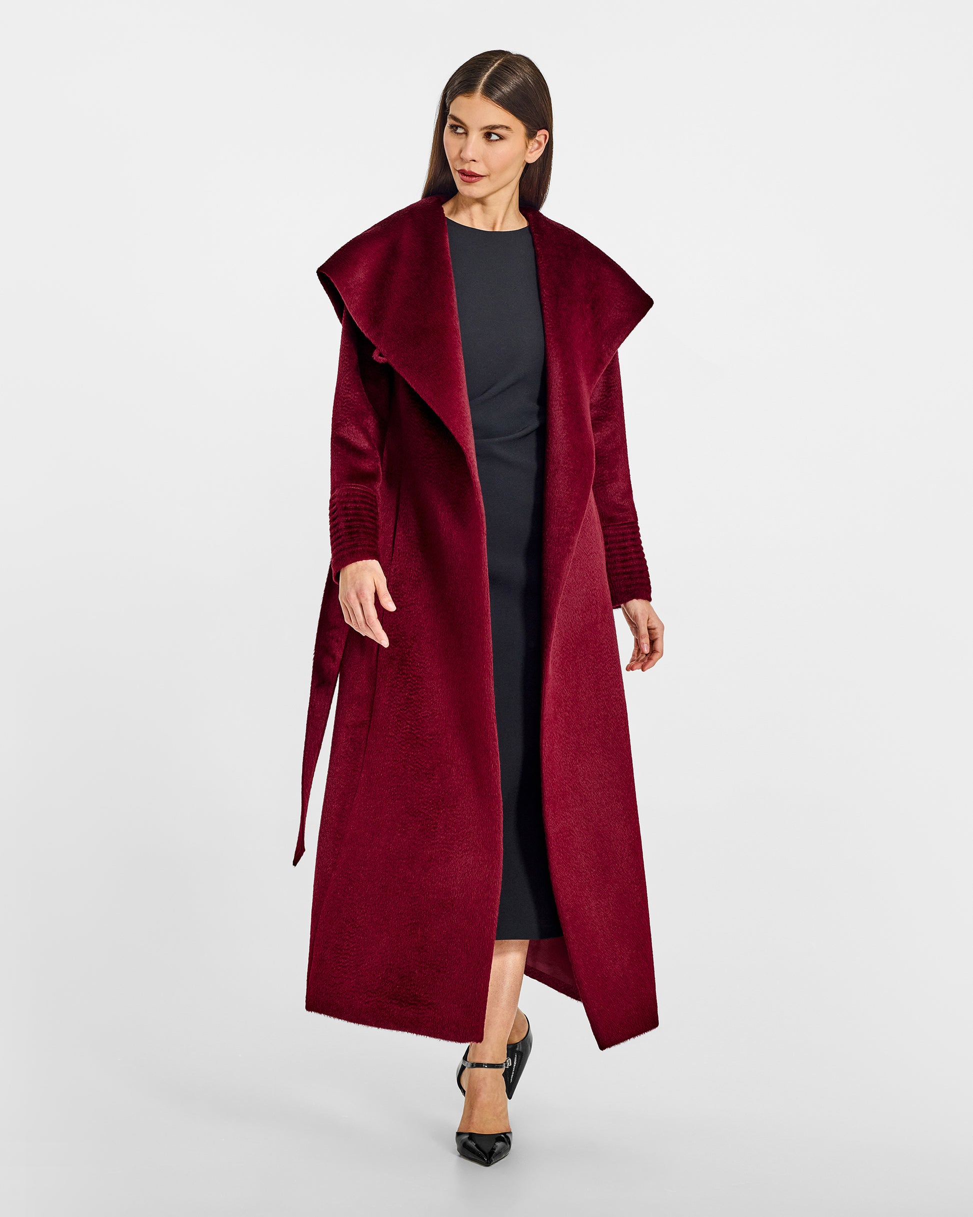 Front view of model wearing a Sentaler maxi bordeaux coat made of suri alpaca wool, with a hooded collar, worn open.