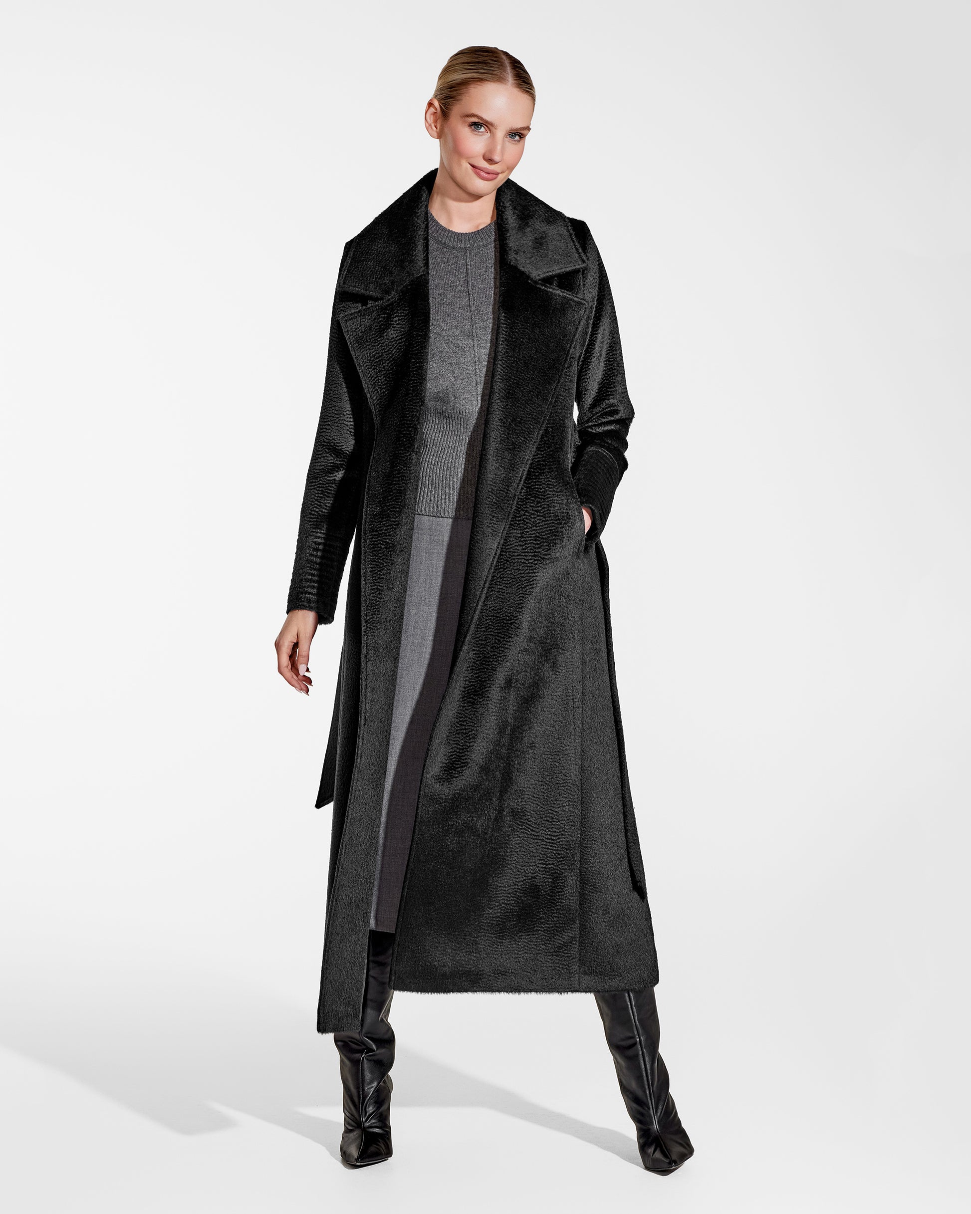 Front view of model wearing a Sentaler black maxi coat made of suri alpaca wool, with a notched collar, worn open.