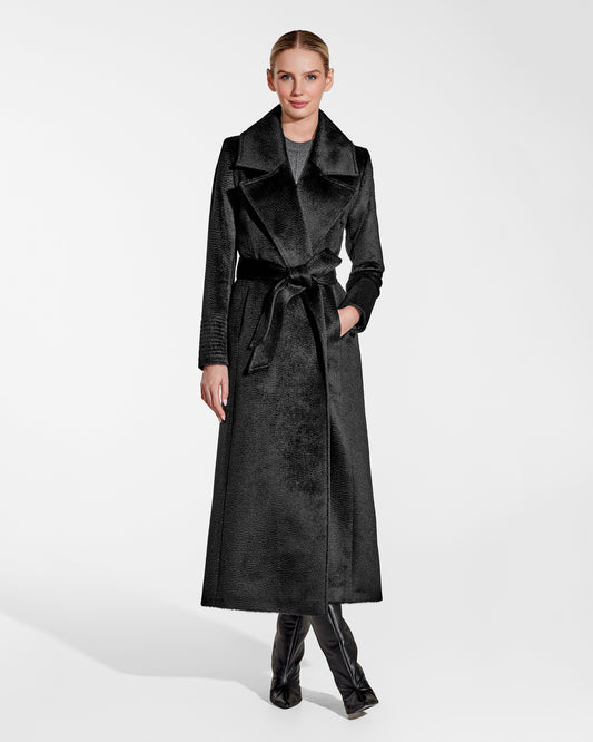 Front view of model wearing a Sentaler black maxi coat made of suri alpaca wool, with a notched collar, worn belted.