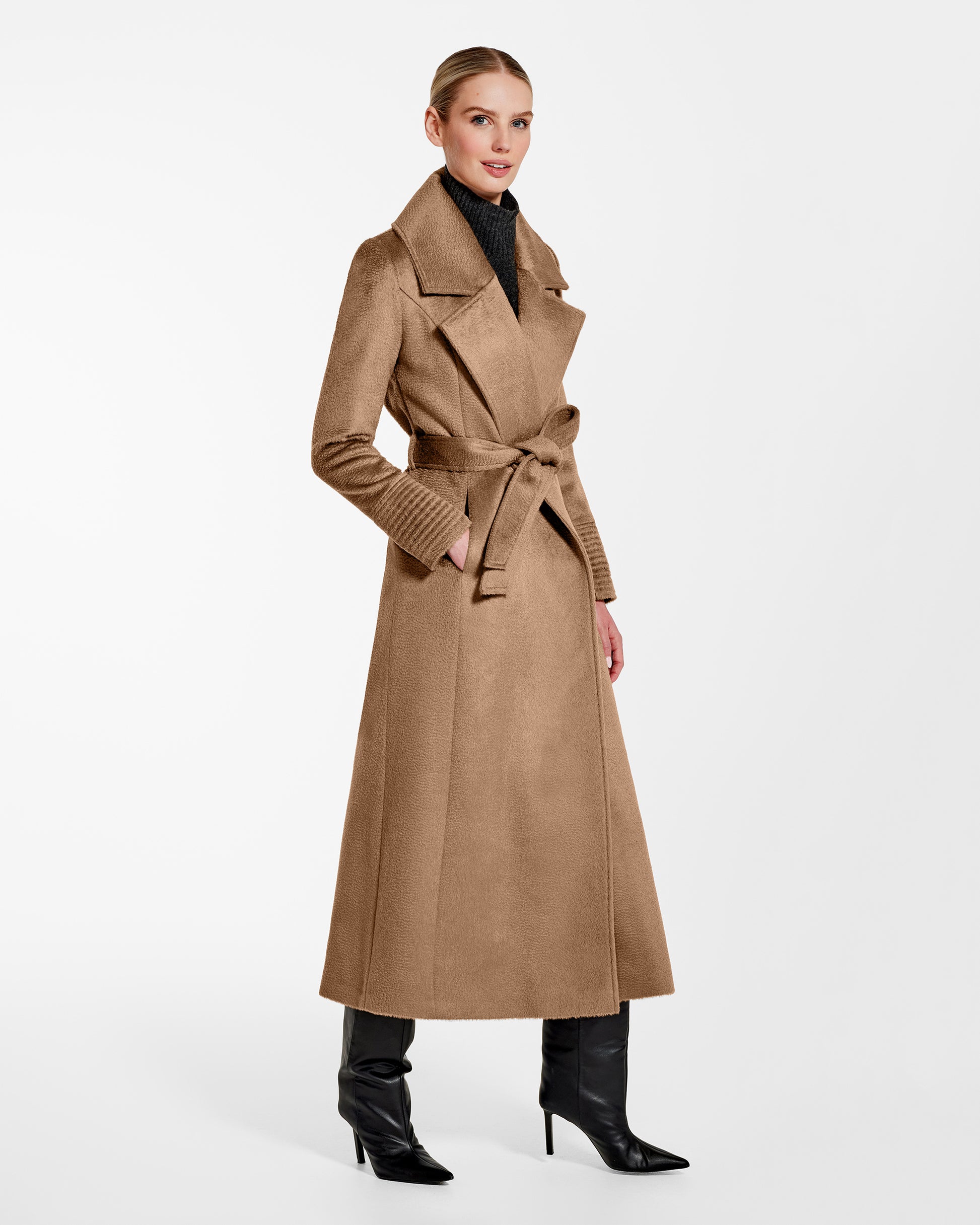 Side view of model wearing a Sentaler dark camel maxi coat made of suri alpaca wool, with a notched collar, worn belted.