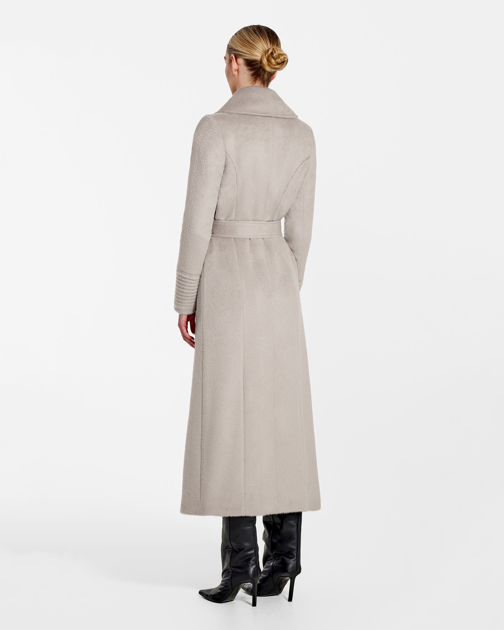 Back view of model wearing a Sentaler sand maxi coat made of suri alpaca wool, with a notched collar, worn belted.