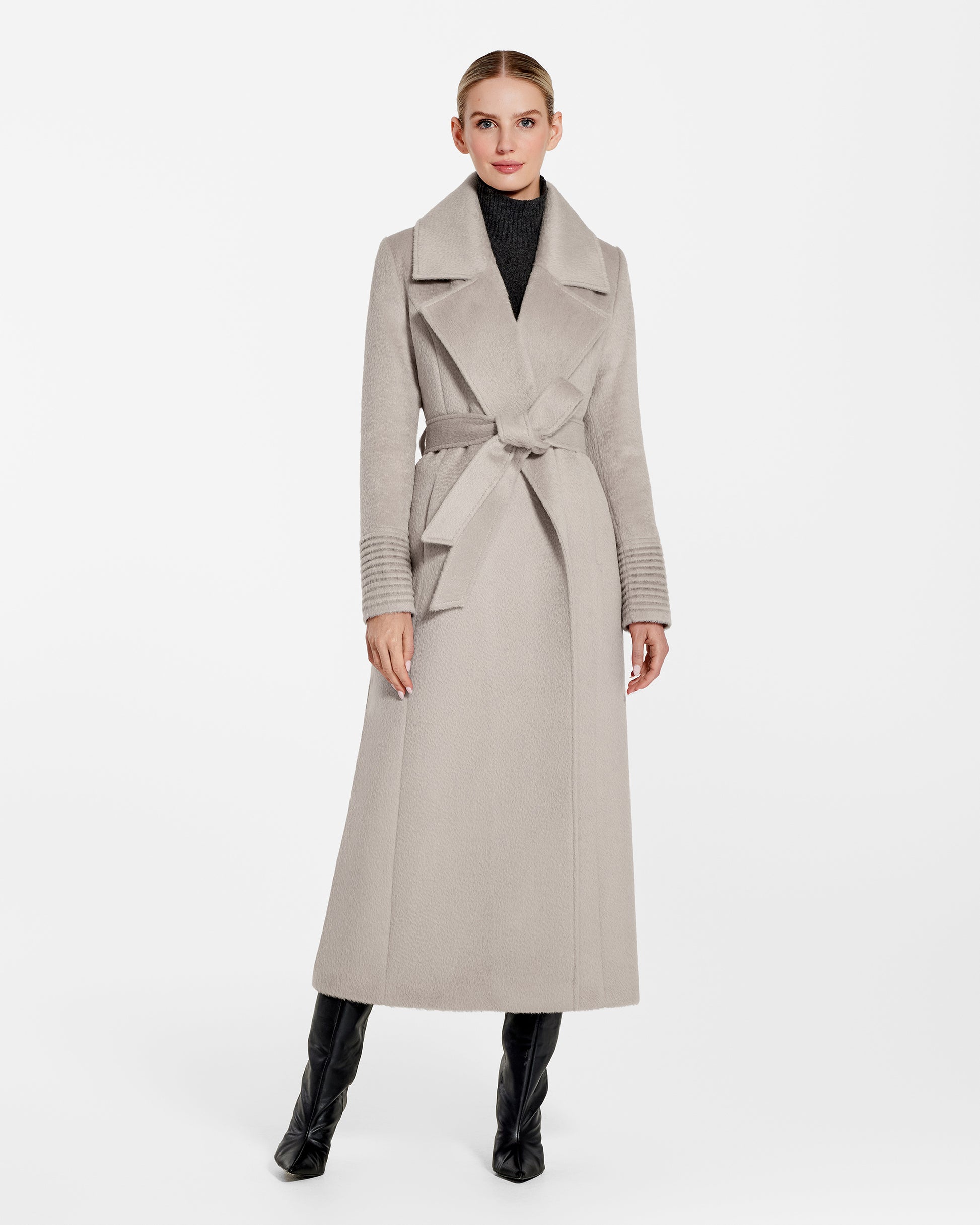 Front view of model wearing a Sentaler sand maxi coat made of suri alpaca wool, with a notched collar, worn belted.