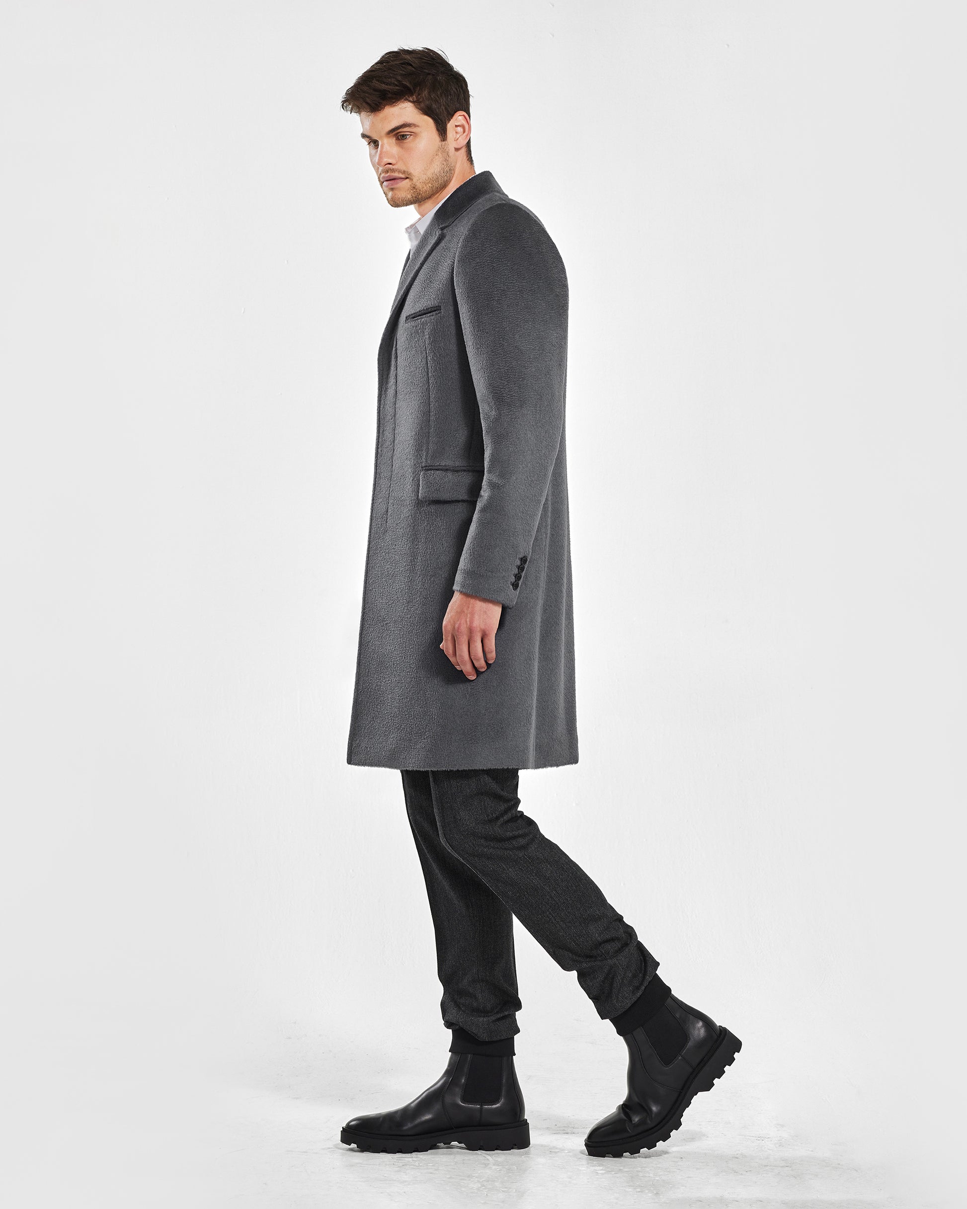 Sentaler Notched Lapel Bold Graphite Grey Overcoat in Suri Alpaca wool. Seen from side on male model, worn buttoned.