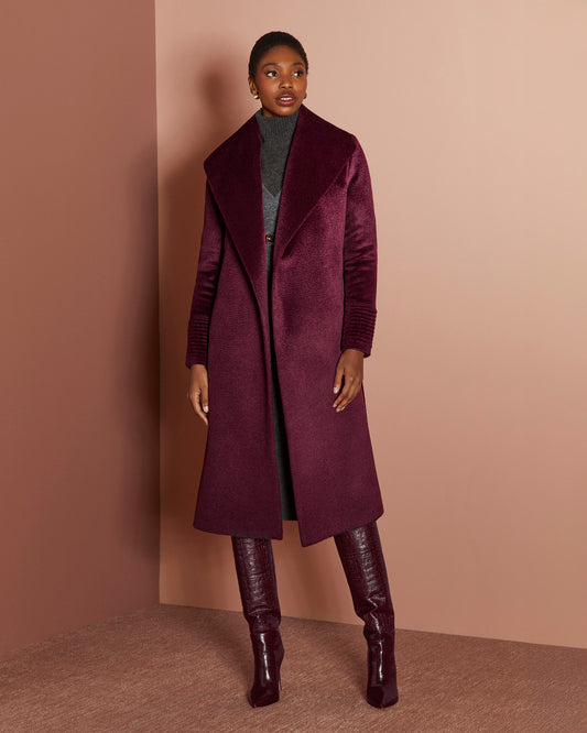 Front view of model wearing a Sentaler long cherry lacquer wrap coat made of suri alpaca wool, with a shawl collar, worn open.