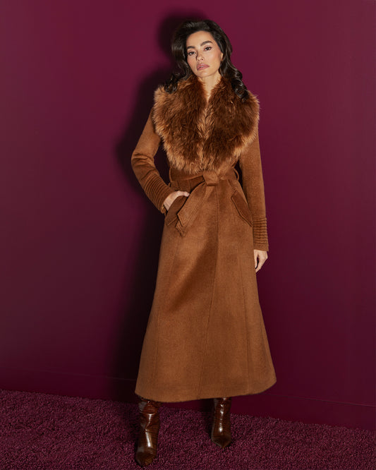 Front view of model wearing a  Sentaler caramel maxi coat made of suri alpaca wool, with an alpaca shearling collar, seen belted.