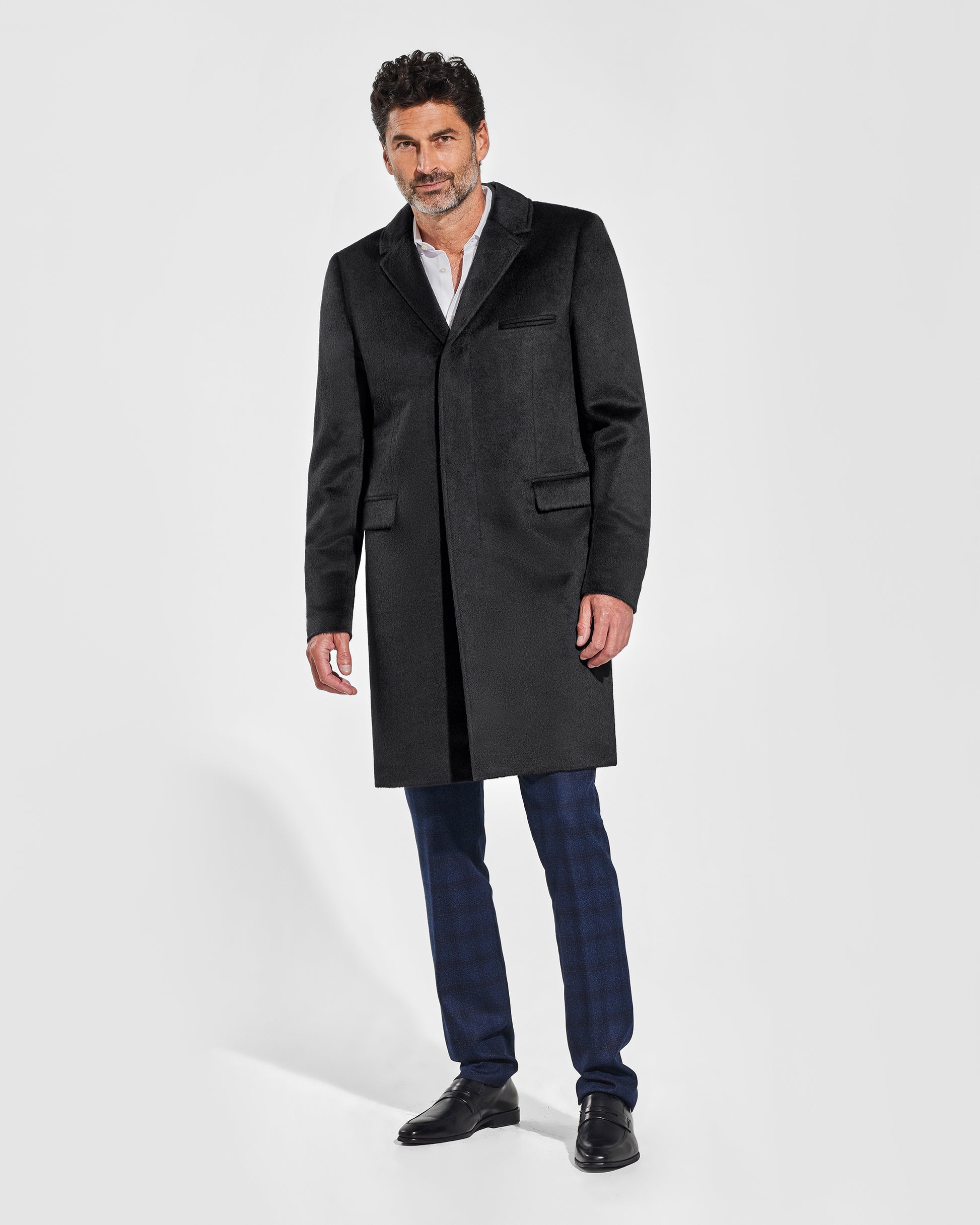 Sentaler Notched Lapel Black Overcoat in Suri Alpaca wool. Seen from front on male model, worn buttoned.