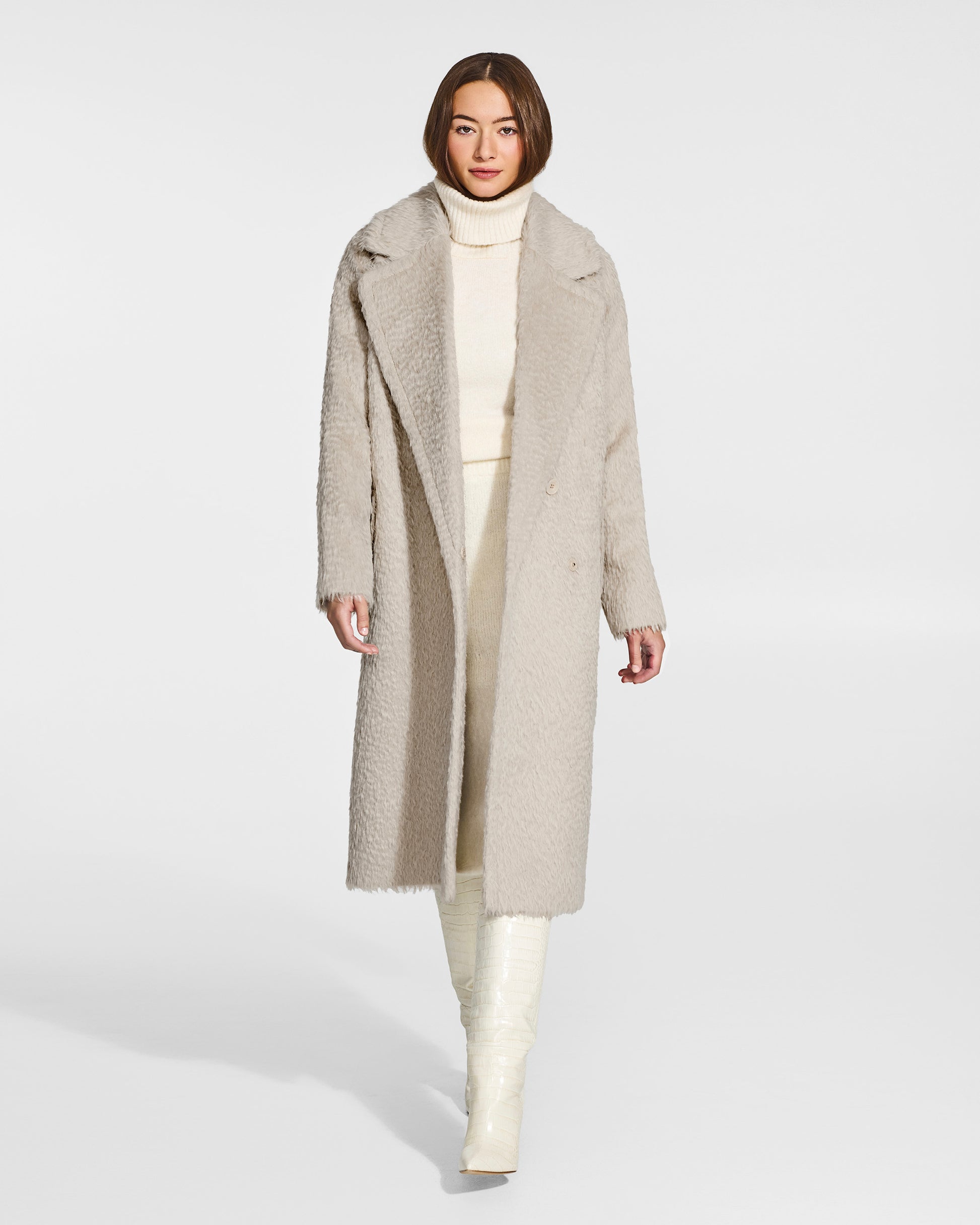 Front view of model wearing a Sentaler oat notched collar coat made of textured suri alpaca wool, with raglan sleeves, worn open.