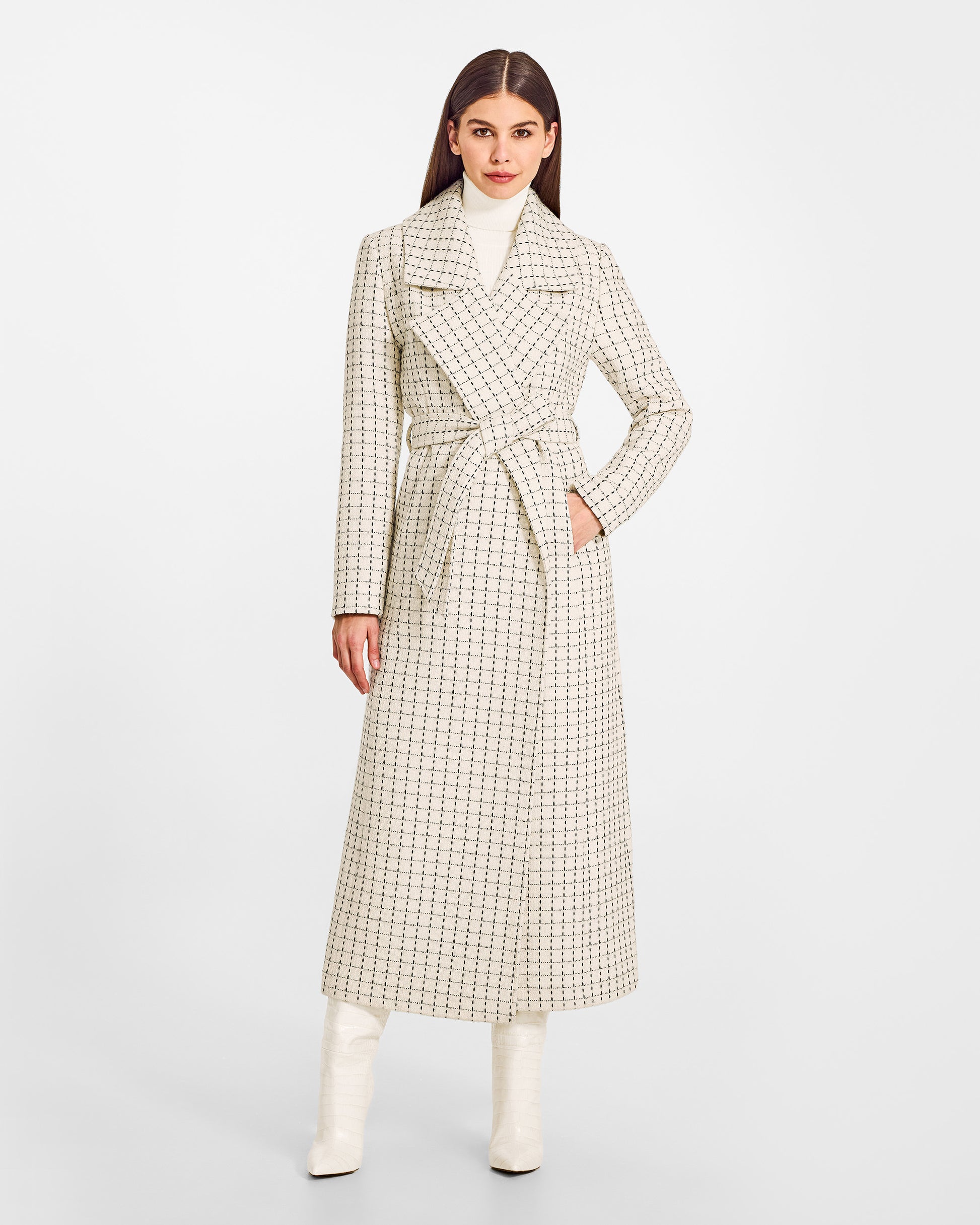 Front view of model wearing a Sentaler ivory check maxi coat made of suri alpaca wool, with a notched collar, worn belted.