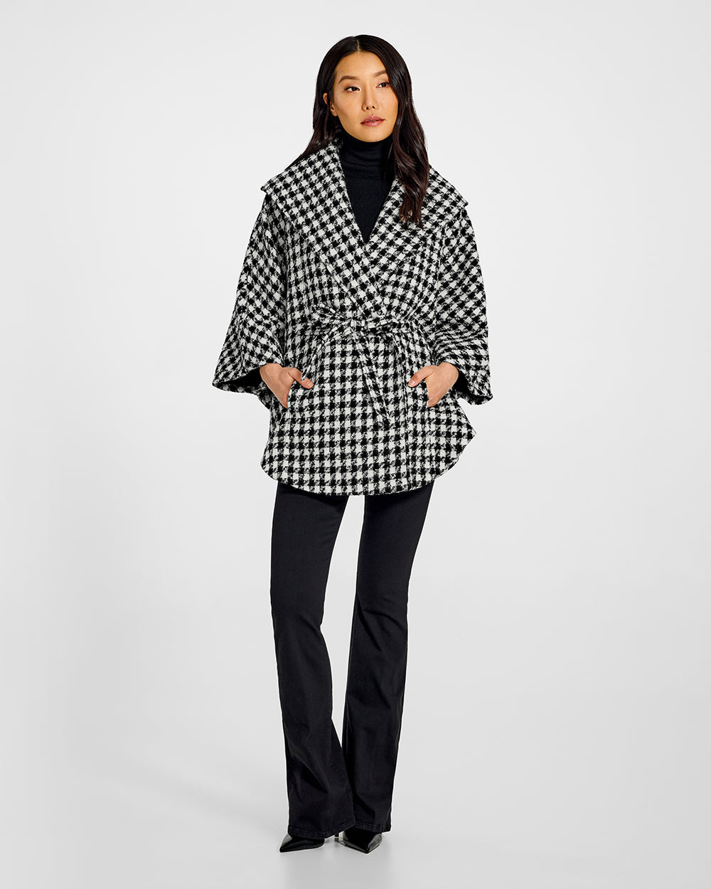 Sentaler Tweed Black and White Houndstooth Cape in Tweed Suri Alpaca wool. Seen from front belted on female model.