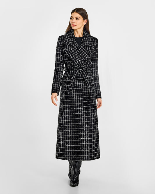 Front view of model wearing a Sentaler black check maxi coat made of tweed suri alpaca wool, with a notched collar, worn belted.