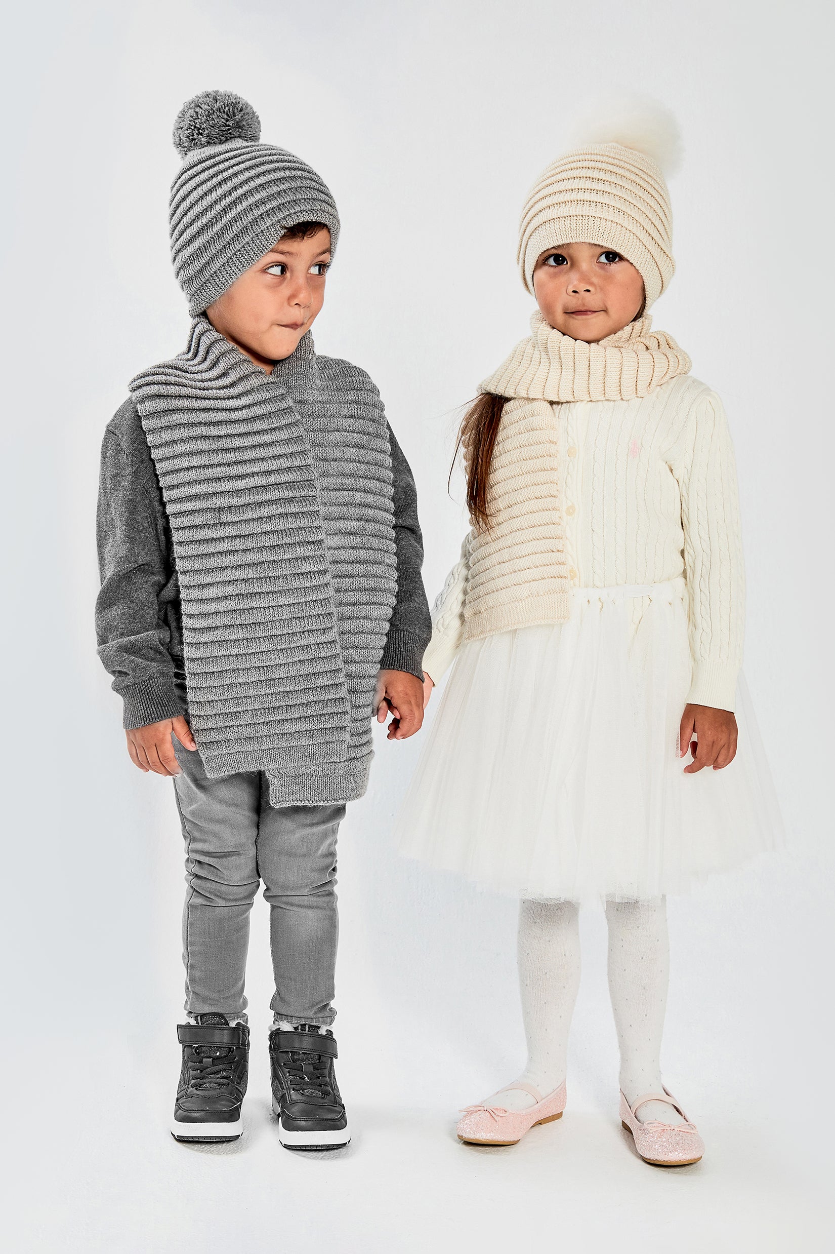 Front view close of models wearing Sentaler's signature ivory and grey ribbed hat and scarf.