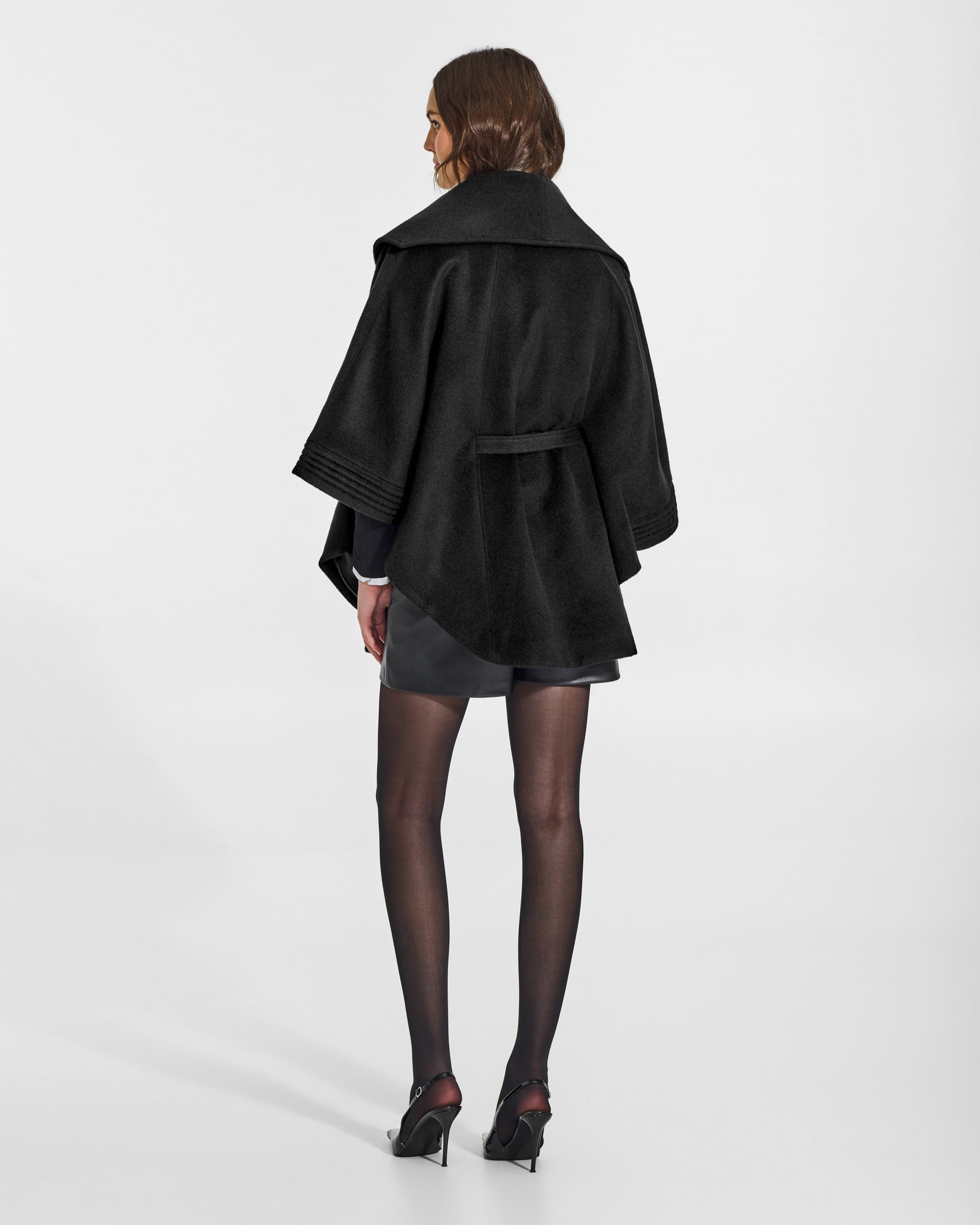 SENTALER Cape with Shawl Collar and Belt in Black, Baby Alpaca. Worn by a female model, back view, belted.
