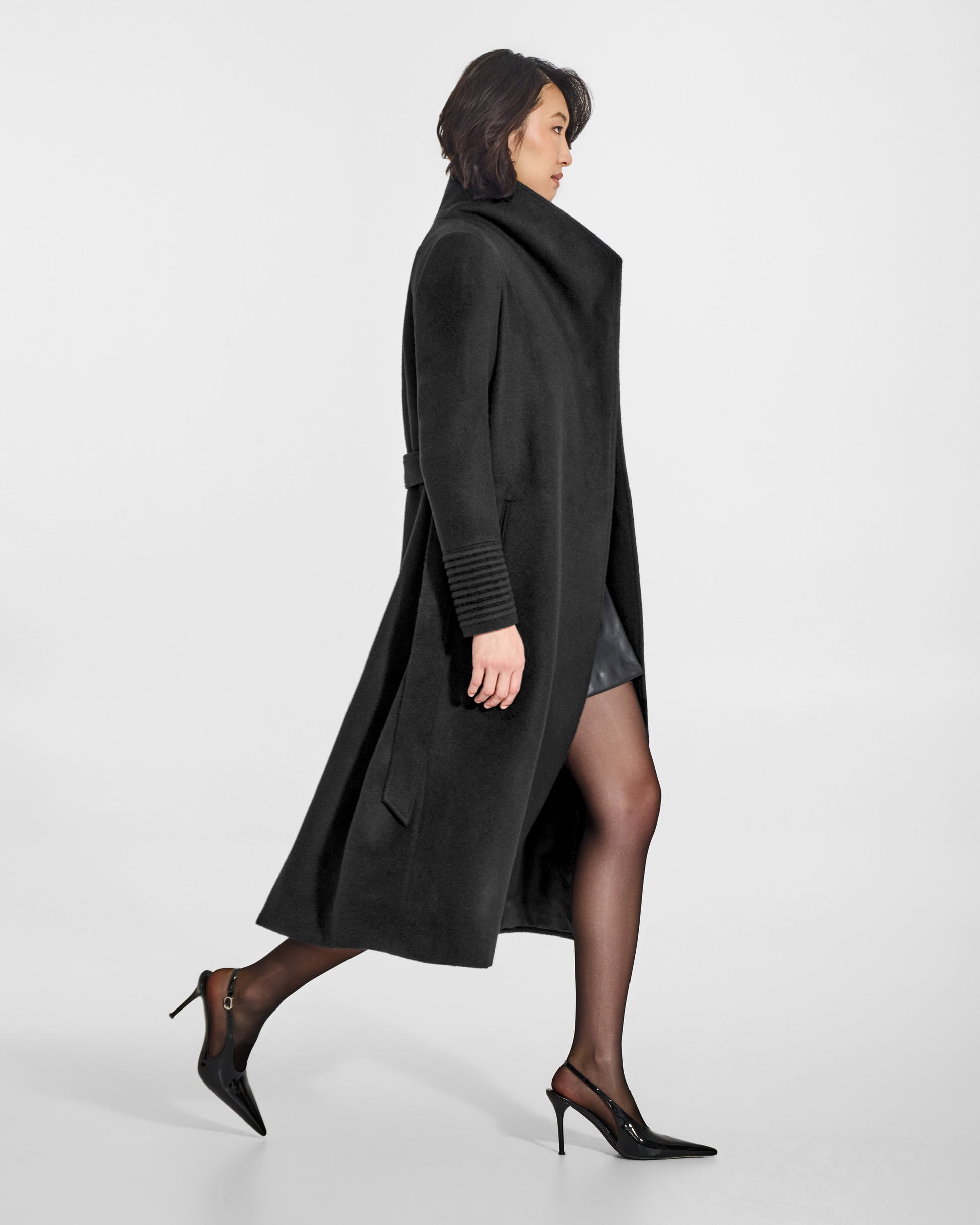 SENTALER Long Funnel Collar Wrap Coat in Black, Baby Alpaca. Worn by a female model, side view, belted.