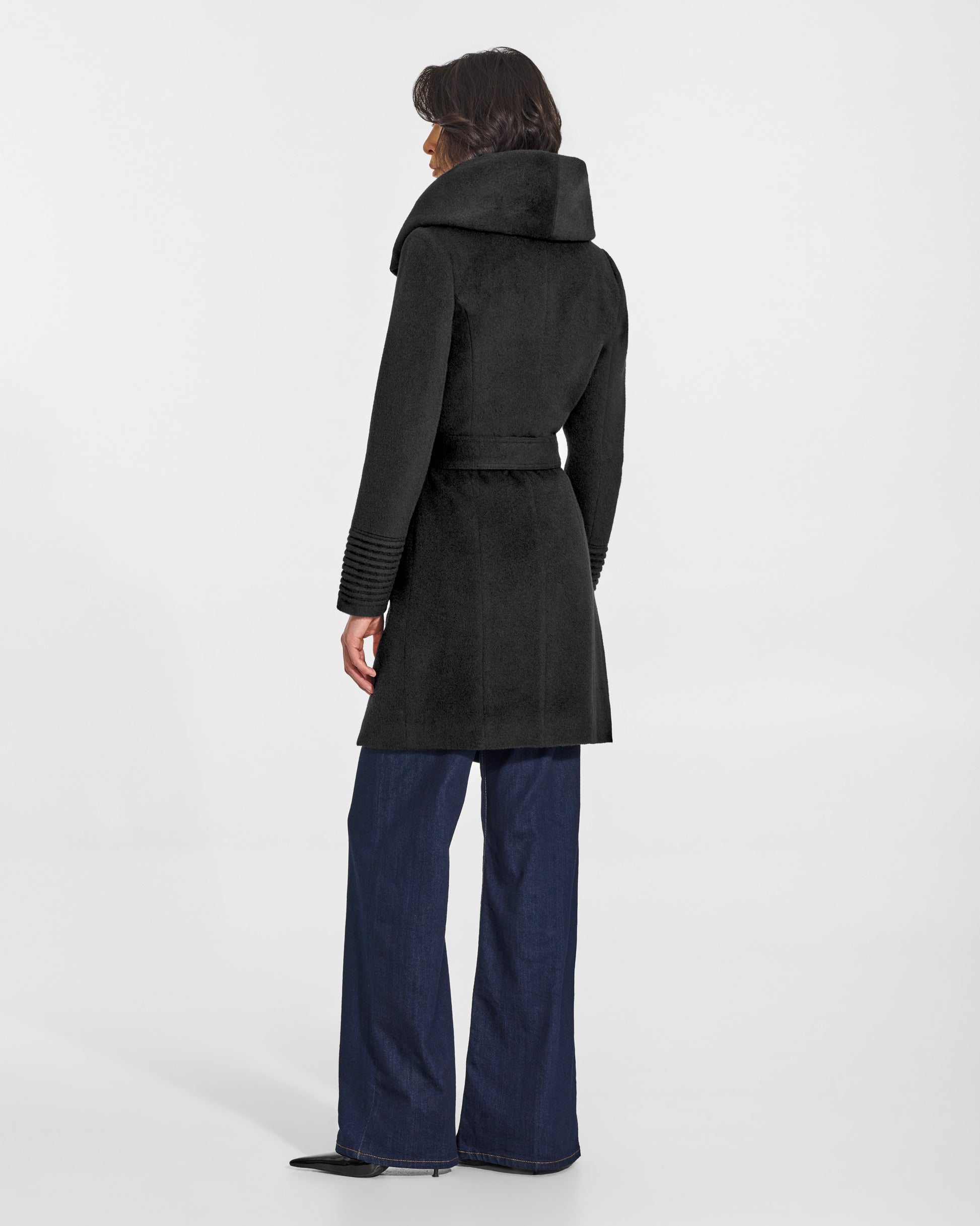 SENTALER Mid Length Hooded Wrap Coat in Black, Baby Alpaca. Worn by a female model, back view, belted.