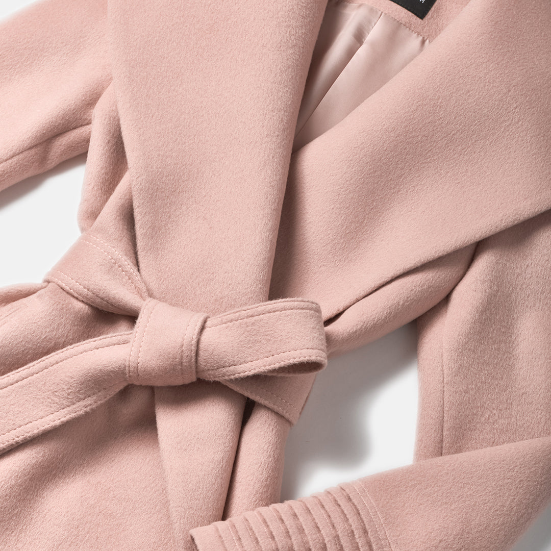 Close-up of baby alpaca blush pink coat with a tie waist.