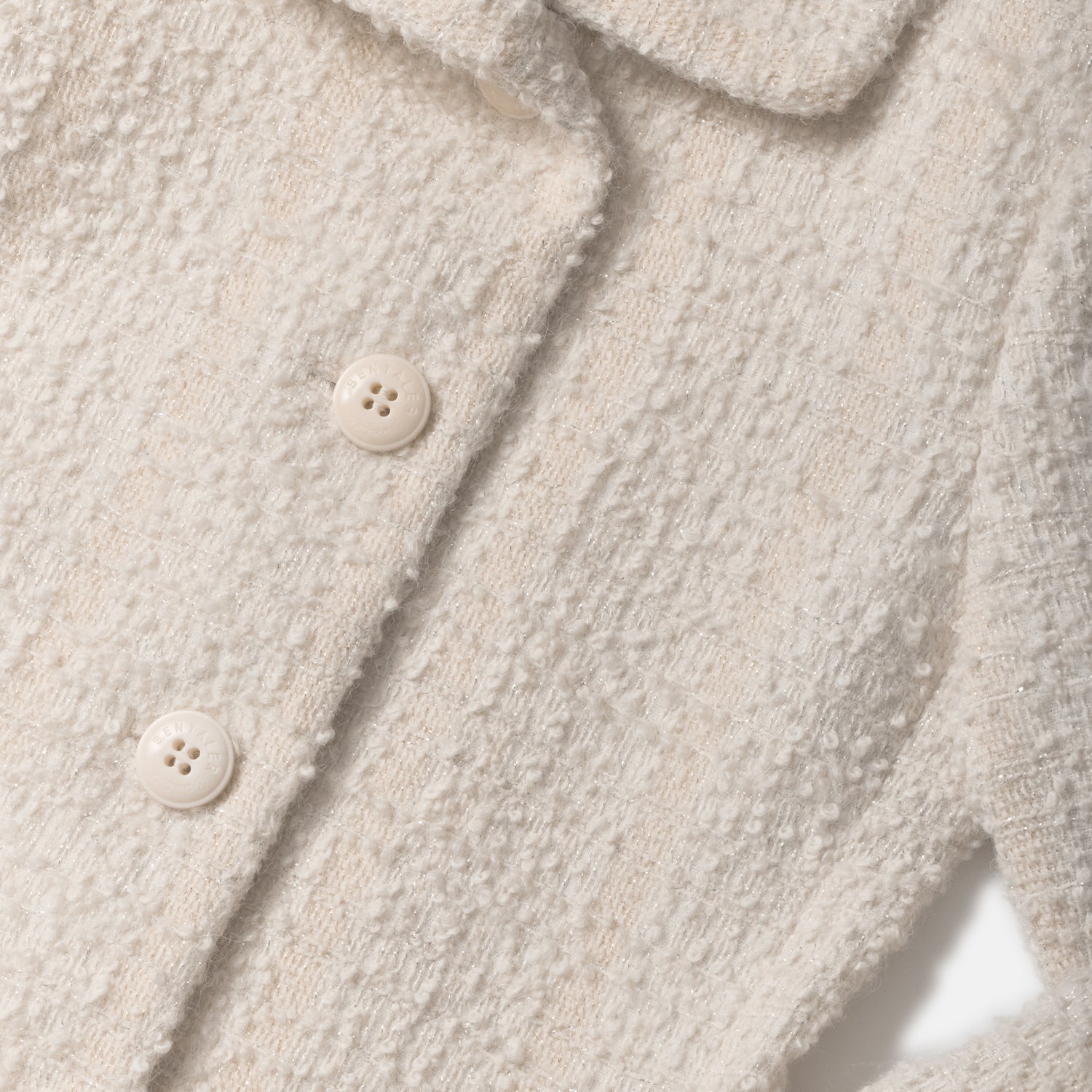 Close-up of a glittered tweed suri alpaca coat with buttons.