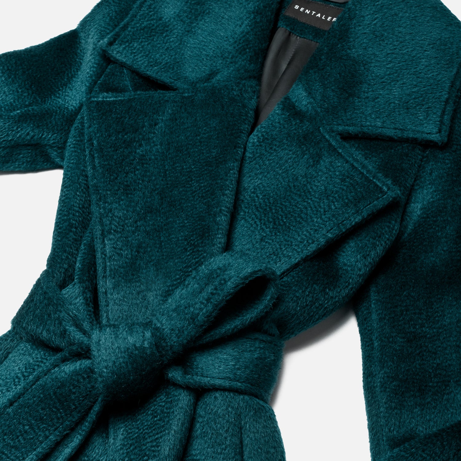 Close up of suri alpaca emerald green coat with a tie.