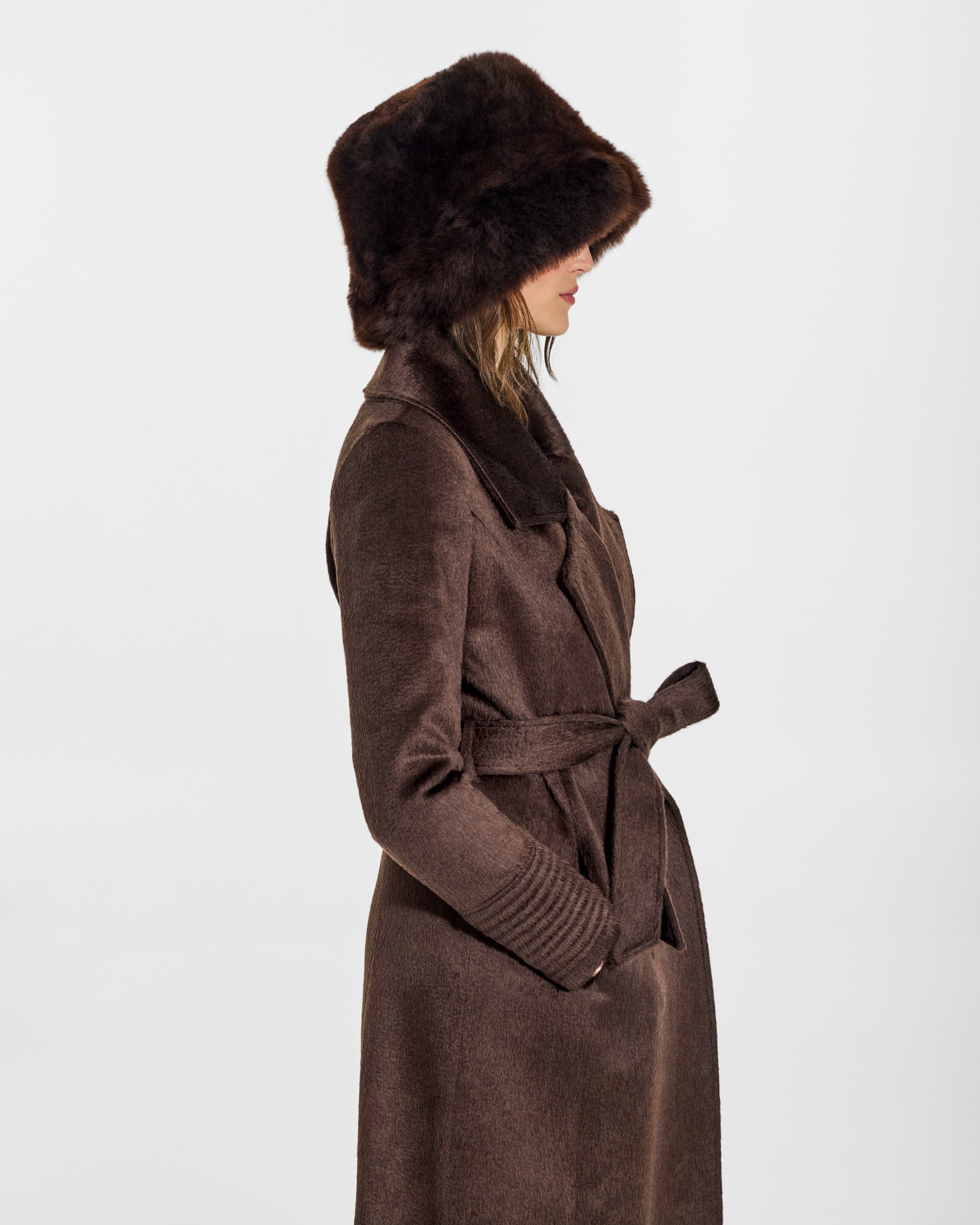 SENTALER Oversized Shearing Bucket Hat in Chocolate Brown, Alpaca Shearling. Worn by a female model, side view, belted.