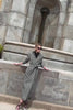 Video of a model wearing a Sentaler Black and White Houndstooth Tweed Suri Alpaca Long Raglan Sleeve Wrap Coat, with a stone fountain in the background.