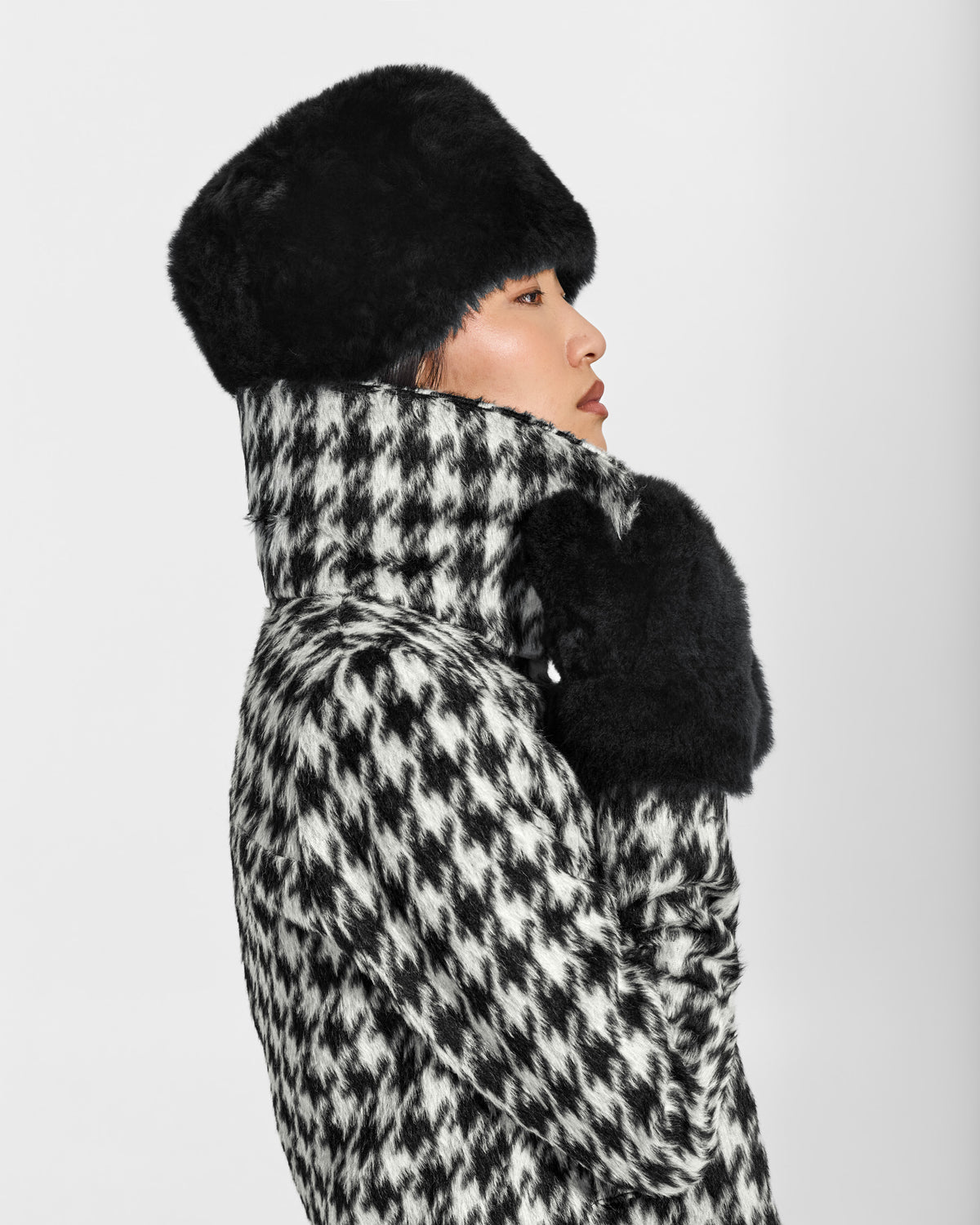 SENTALER Shearling Hat in Black, Alpaca Shearling. Worn by a female model, side view.